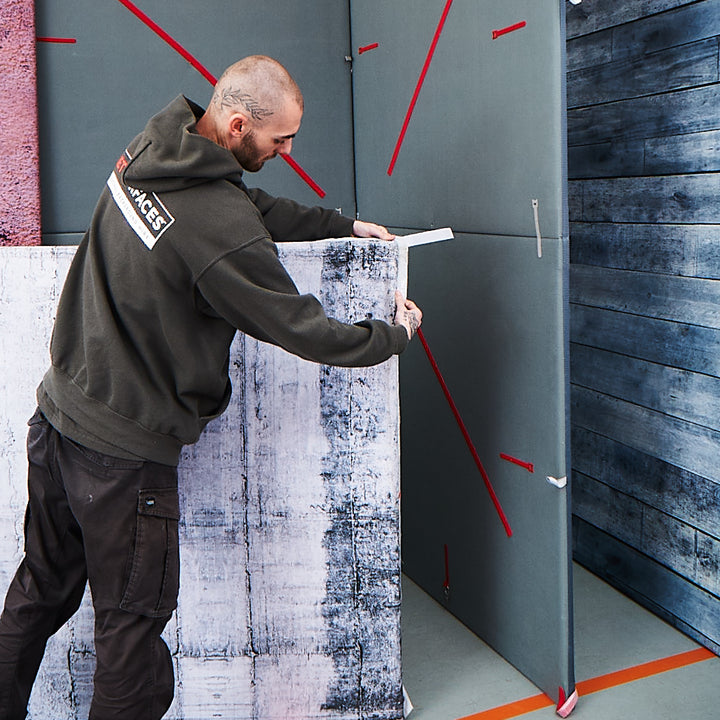 A Set Surface member of staff securing a SETskin which is a printed fabric photography backdrop onto a SETpanel which is a light weight panel that creates a photoshoot background